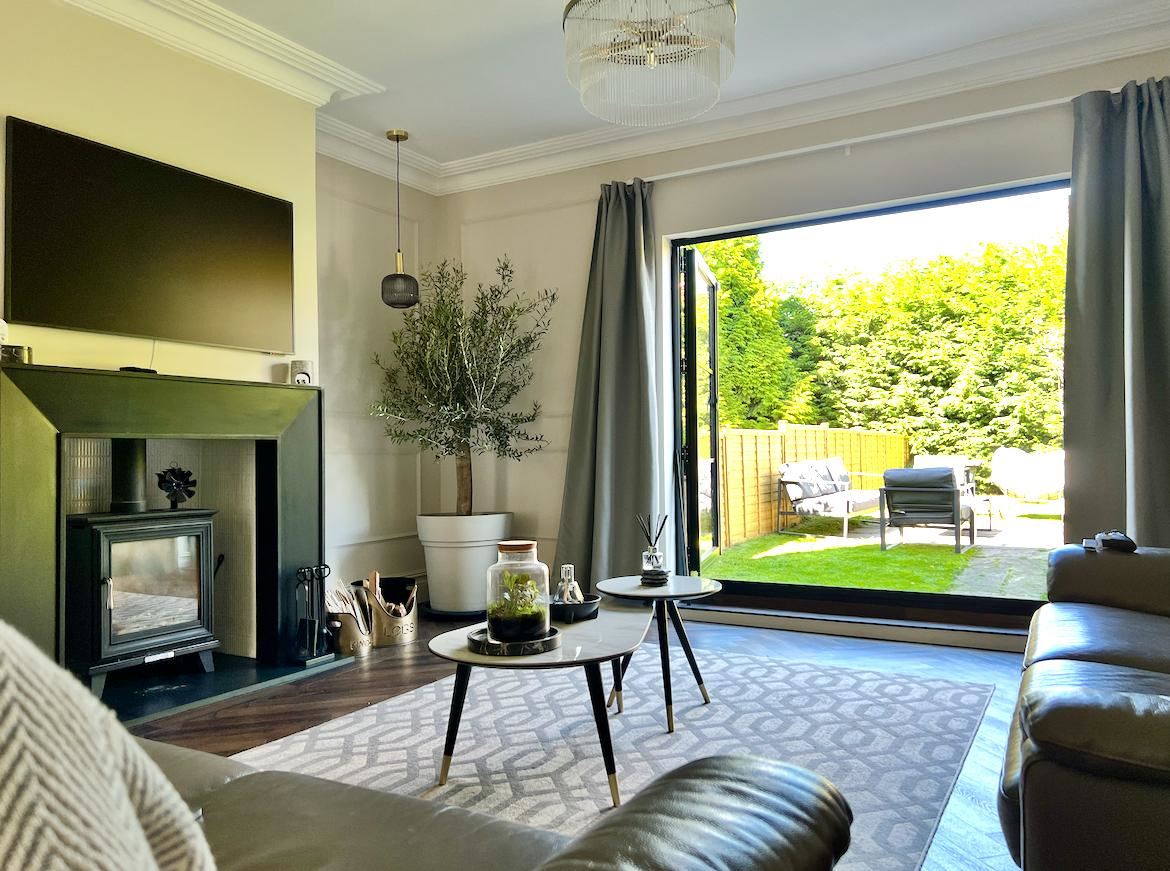 Our bright living room, with a log burner and big glass doors opening onto the garden